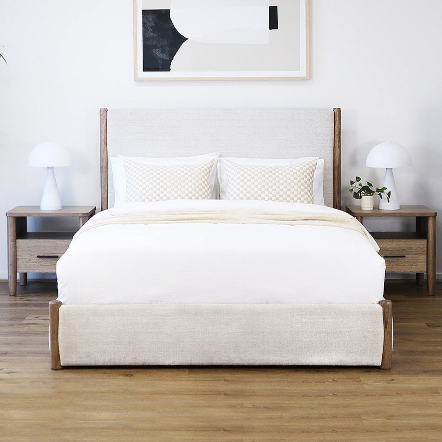 Queen and king size bed with white bedding, wooden frame, and matching nightstands