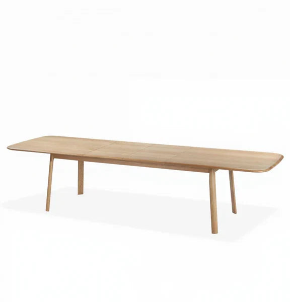 Light wood extendable dining table with rounded corners and slender legs