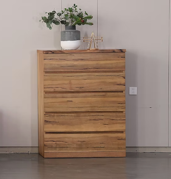 Wooden bedroom dresser with stacked drawers and a plant on top, natural wood grain