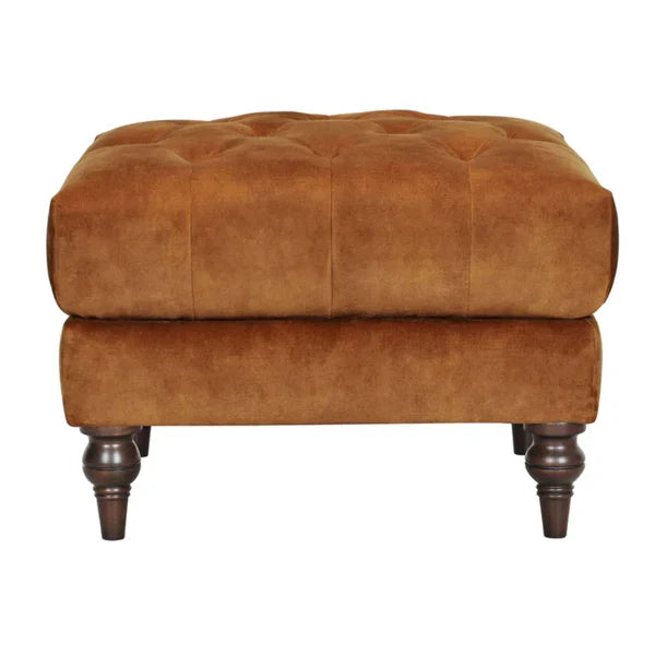 Warm brown velvet Chesterfield sofa close-up with buttoned seat and rolled arms