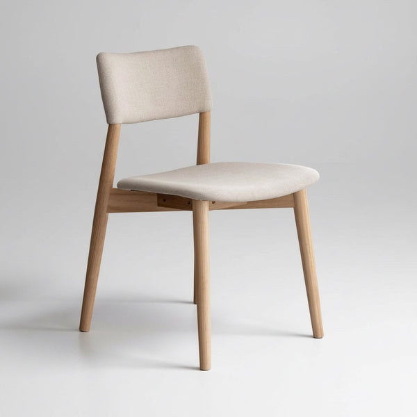 Upholstered dining chair with light fabric seat and back, natural wood legs