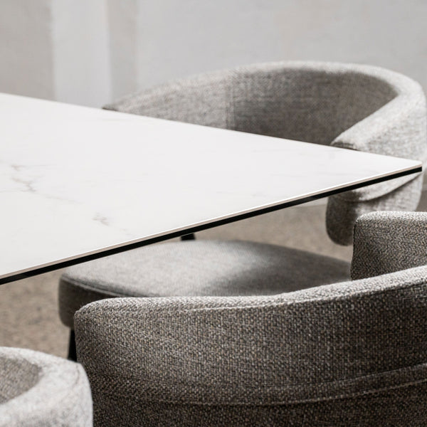 Marble-look tabletop corner with veining and gray chair upholstery