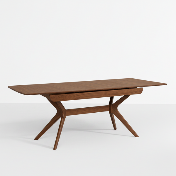 A mid-century modern wooden dining table with a rectangular brown wood top and sculptural X-shaped legs, shown on a clean white studio background.